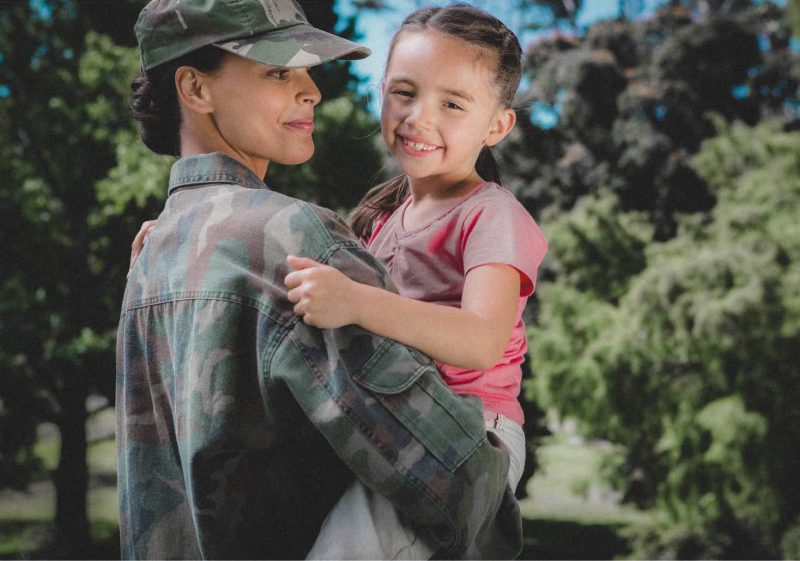 female soldier holding little girl